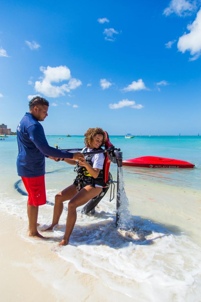 Un empleado de Red Sail ayuda a un trabajador a trabajar con un waterjetpack.
